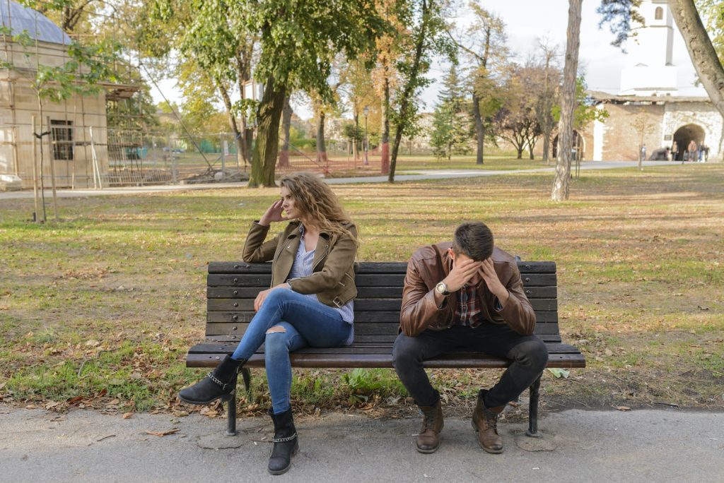 Woman And Man Sitting on Brown Wooden Bench