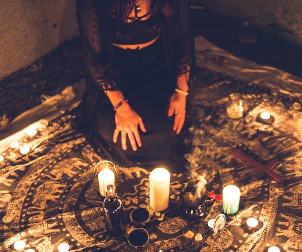 Sorceress among candles in darkness